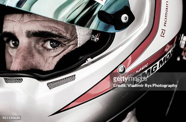 Romain Dumas of France and Porsche 919 Hybrid sits in his car during the Le Mans 24 Hour Race at Circuit de la Sarthe on June 15, 2014 in Le Mans,...
