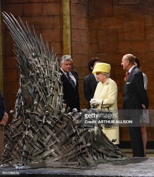 Britain's Queen Elizabeth II and Prince Philip, the Duke of Edinburgh view the giant "Iron Throne" prop during their visit to the set of the HBO TV...