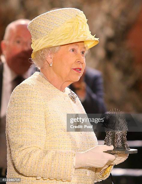 Queen Elizabeth II receives a miniature 'Iron Throne' in the Throne Room as she meets cast members of the HBO TV series 'Game of Thrones' on set in...