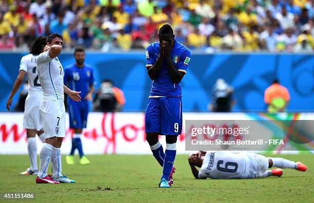 Mario Balotelli of Italy reacts after colliding with Alvaro Pereira of Uruguay during the 2014 FIFA World Cup Brazil Group D match between Italy and...