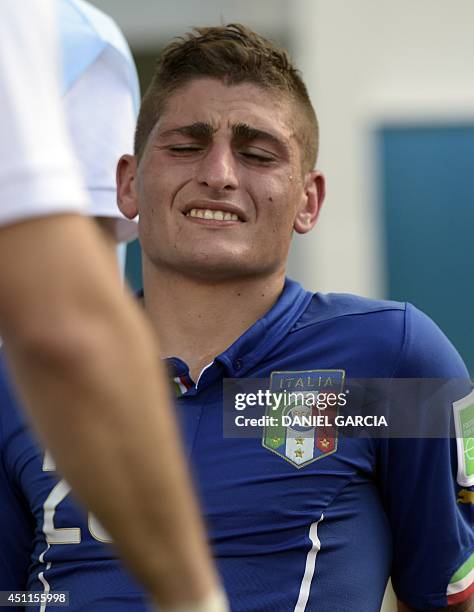 Italy's midfielder Marco Verratti reacts as he is stretched out during a Group D football match between Italy and Uruguay at the Dunas Arena in Natal...