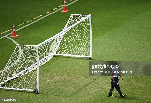 Iran's goalkeeper Alireza Haghighi walks over the pitch as his team visits at the Fonte Nova Arena in Salvador on June 24 on the eve of their 2014...