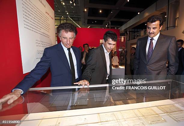 The President of the Institut du Monde Arabe Jack Lang and Qatar Emir Sheikh Tamim Ben Hamad Al Thani look at documents during a visit of the...