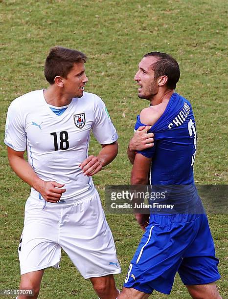Giorgio Chiellini of Italy pulls down his shirt after a clash with Luis Suarez of Uruguay as Gaston Ramirez of Uruguay looks on during the 2014 FIFA...