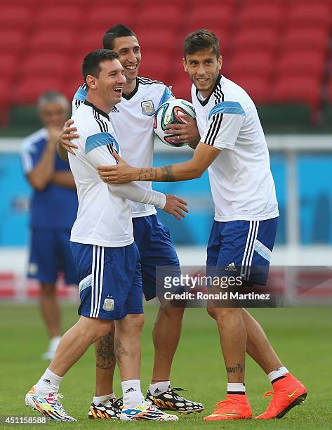 Lionel Messi of Argentina has a laugh with Angel Di Maria and Ricardo Alvarez during a training session at Estadio Beira-Rio on June 24, 2014 in...