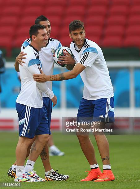 Lionel Messi of Argentina has a laugh with Angel Di Maria and Ricardo Alvarez during a training session at Estadio Beira-Rio on June 24, 2014 in...