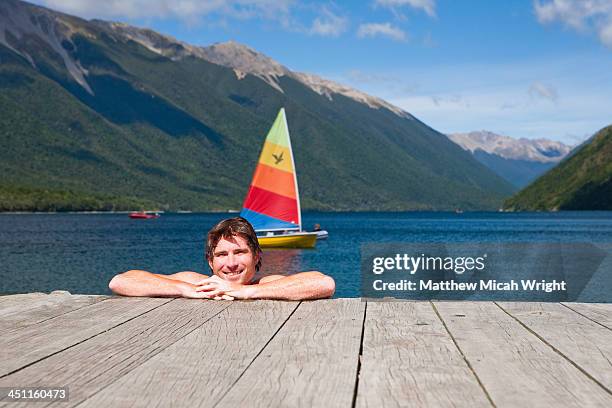 a man cools off with a swim on a hot afternoon. - nelson lakes national park stock pictures, royalty-free photos & images