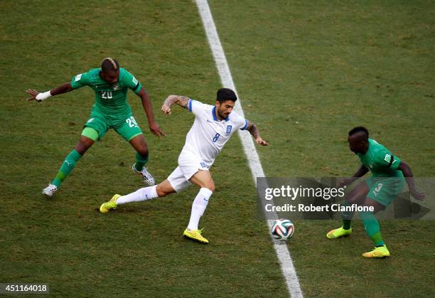 Panagiotis Kone of Greece is challenged by Die Serey and Arthur Boka of the Ivory Coast during the 2014 FIFA World Cup Brazil Group C match between...