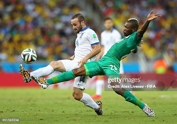 Dimitris Salpingidis of Greece and Die Serey of the Ivory Coast compete for the ball during the 2014 FIFA World Cup Brazil Group C match between...