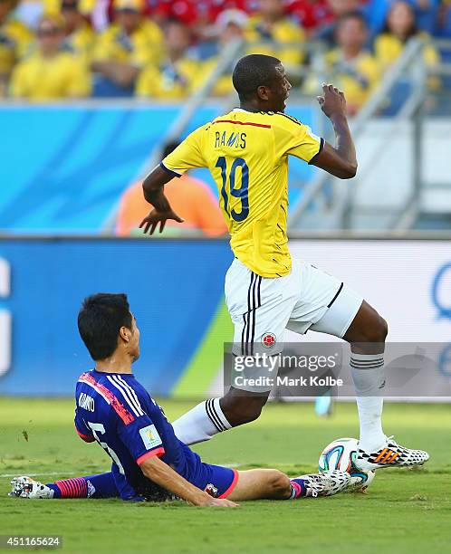 Yasuyuki Konno of Japan fouls Adrian Ramos of Colombia during the 2014 FIFA World Cup Brazil Group C match between Japan and Colombia at Arena...