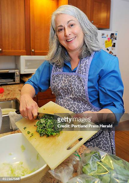 Denise Tepler adds the chopped mint leaves from Patchwork Gardens in Brunswick into the grated onion as she makes grilled burgers using ground lamb...