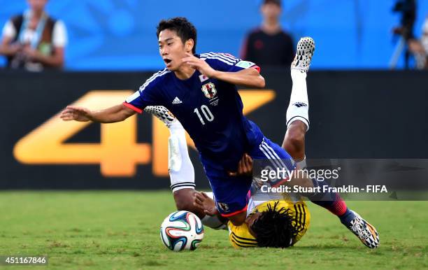 Shinji Kagawa of Japan is tackled by Juan Guillermo Cuadrado of Colombia during the 2014 FIFA World Cup Brazil Group C match between Japan and...