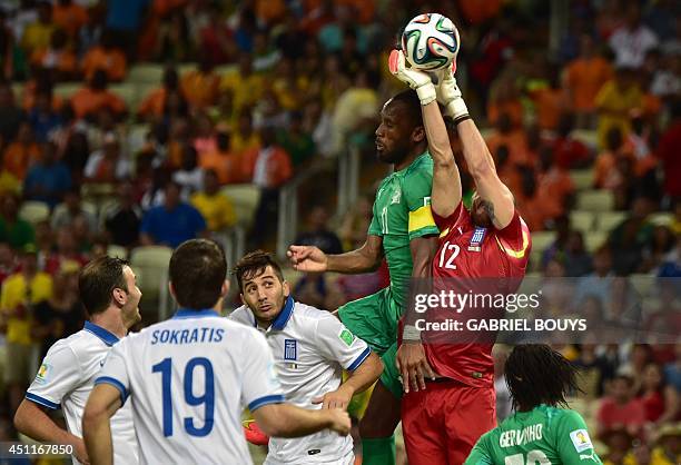 Greece's goalkeeper Panagiotis Glykos fights for the ball with Ivory Coast's forward and captain Didier Drogba during a Group C football match...