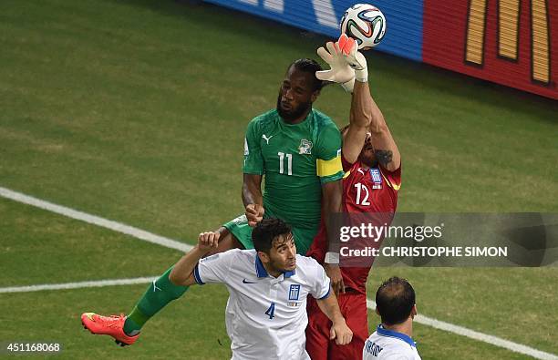 Greece's goalkeeper Panagiotis Glykos blocks a shot on goal by Ivory Coast's forward and captain Didier Drogba during the Group C football match...