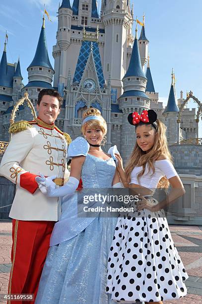 In this handout photo provided by Disney Parks, singer Ariana Grande poses with Cinderella and Prince Charming in front of Cinderella Castle in the...