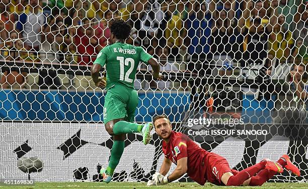 Ivory Coast's forward Wilfried Bony scores in the nets of Greece's goalkeeper Panagiotis Glykos during a Group C football match between Greece and...