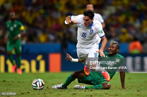 Lazaros Christodoulopoulos of Greece is tackled by Die Serey of the Ivory Coast during the 2014 FIFA World Cup Brazil Group C match between Greece...