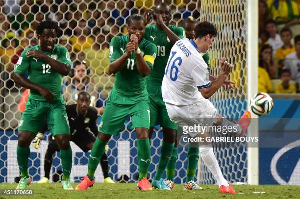 Ivory Coast's forward Wilfried Bony, forward Didier Drogba and midfielder Yaya Toure prepare to block a free kick by Greece's midfielder Lazaros...