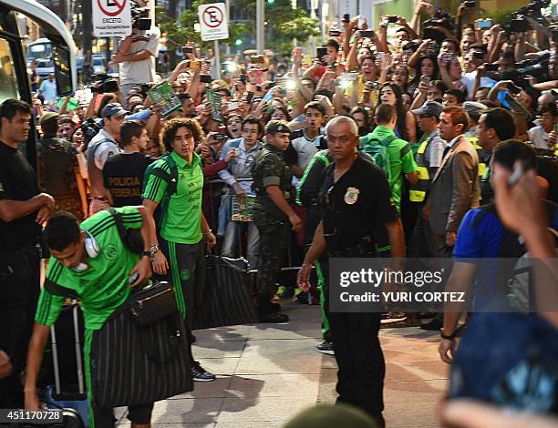 Mexico's goalkeeper Guillermo Ochoa and Mexico's defender Diego Reyes are welcomed by fans as they arrive at their hotel in Santos, Sao Paulo,...