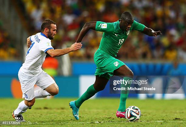 Yaya Toure of the Ivory Coast controls the ball against Dimitris Salpingidis of Greece during the 2014 FIFA World Cup Brazil Group C match between...