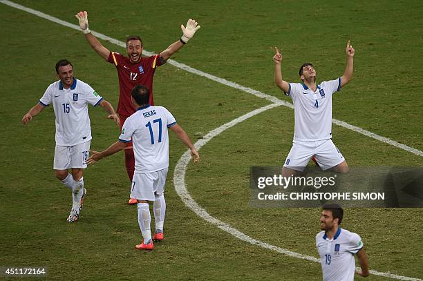 Greece's defender Vasilis Torosidis, goalkeeper Panagiotis Glykos, forward Fanis Gekas and defender Koastas Manolas celebrate at the end of the Group...