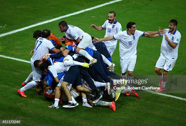 Giorgos Samaras of Greece celebrates with teammates after scoring his team's second goal on a penalty kick during the 2014 FIFA World Cup Brazil...