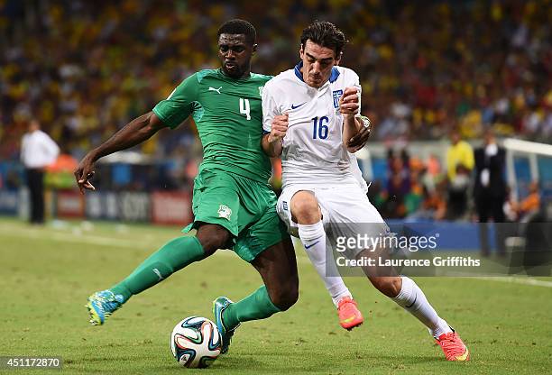 Kolo Toure of the Ivory Coast challenges Lazaros Christodoulopoulos of Greece during the 2014 FIFA World Cup Brazil Group C match between Greece and...