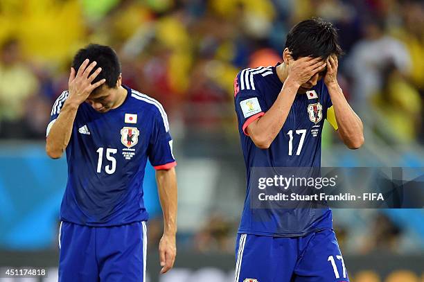 Yasuyuki Konno and Makoto Hasebe of Japan look dejected after the 2014 FIFA World Cup Brazil Group C match between Japan and Colombia at Arena...