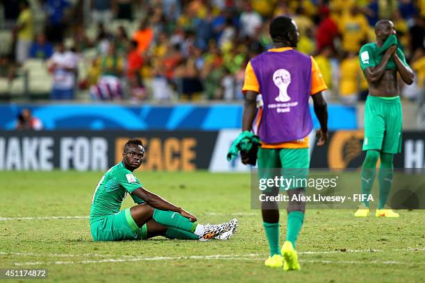Dejected Ismael Diomande of the Ivory Coast sits on the field after being defeated by Greece 2-1 during the 2014 FIFA World Cup Brazil Group C match...