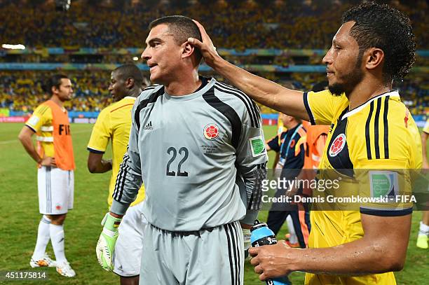 Faryd Mondragon of Colombia is congratulated by his teammate Carlos Valdes after the 4-1 win in the 2014 FIFA World Cup Brazil Group C match between...