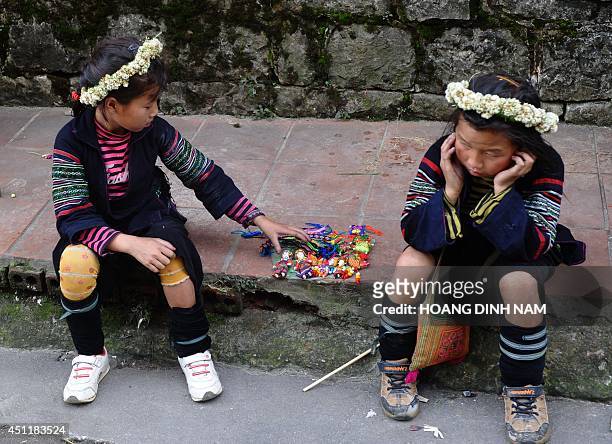 This picture taken on May 10, 2014 shows H'mong ethnic girls selling souvenir items in the tourist town of Sapa, northern Vietnamese province of Lao...
