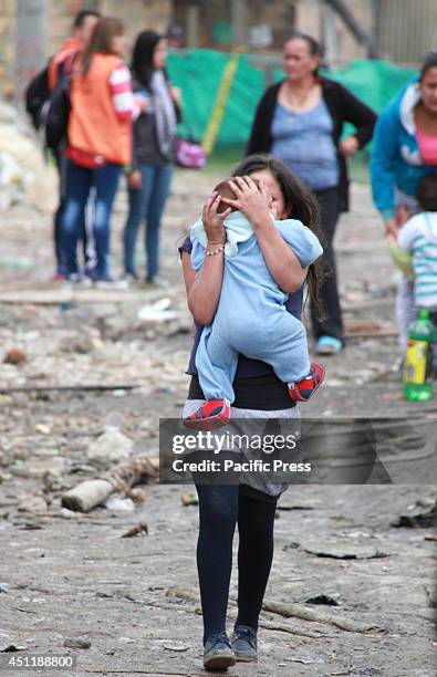 The girl carries a baby in a poor neighborhood located in northwestern Bogotá after a fire that occurred on the evening of June the 23rd ; 120...