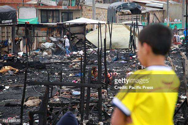 Boy looking the rubble of a fire that occurred on the evening of June the 23rd in a poor neighborhood located in northwestern Bogotá; 120 children...