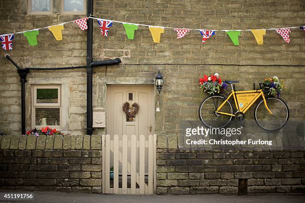 Yellow bicycle hangs from the wall of a stone cottage as Yorkshire prepares to host the Tour de France Grand Depart, on June 24, 2014 in Holmfirth,...