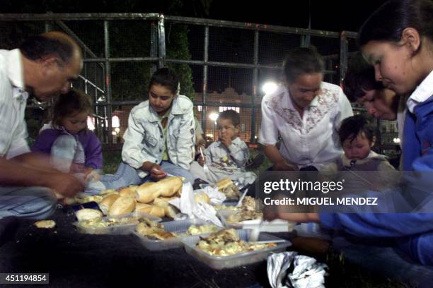 Pedro Espinoza and hisr family share the supper at the Plaza de Mayo, in front of the President's residence in Buenos Aires, Argentina, 24 December...