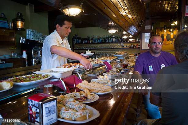 Tapas raciones being served in Taberna La Cierbanata bar in Meson Marinero at Castro Urdiales in Cantabria, Spain