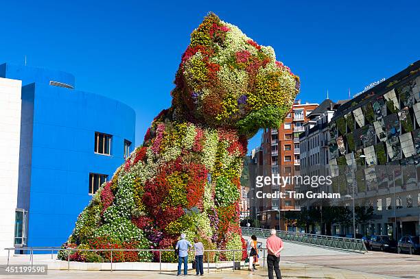 Tourists at Puppy by Jeff Koons floral art in dog form at Guggenheim Museum by Silken Gran Hotel Domine in Bilbao, Spain