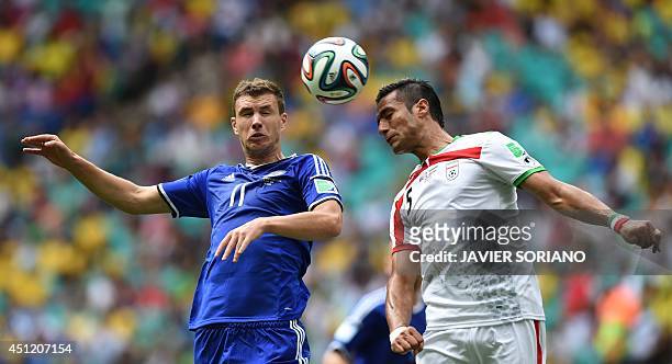 Iran's defender Amir Hossein Sadeghi and Bosnia-Herzegovina's forward Edin Dzeko vie for the ball during a Group F football match between...