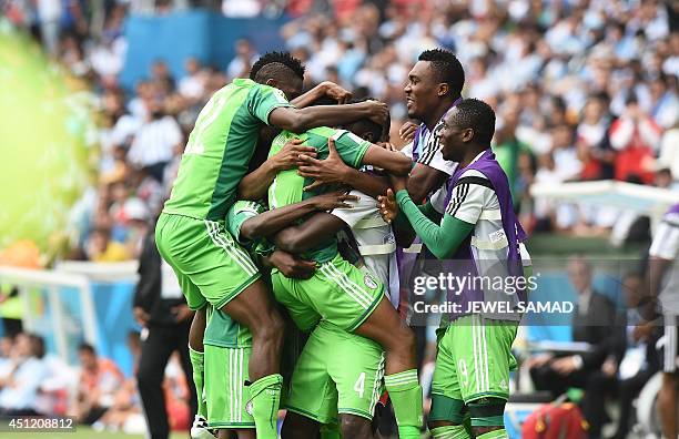 Nigeria's forward Ahmed Musa is mobbed by teammates as he celebrates scoring during the Group F football match between Nigeria and Argentina at the...