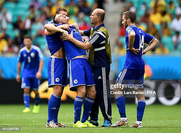 Toni Sunjic of Bosnia and Herzegovina is checked by a medical staff after a clash during the 2014 FIFA World Cup Brazil Group F match between...