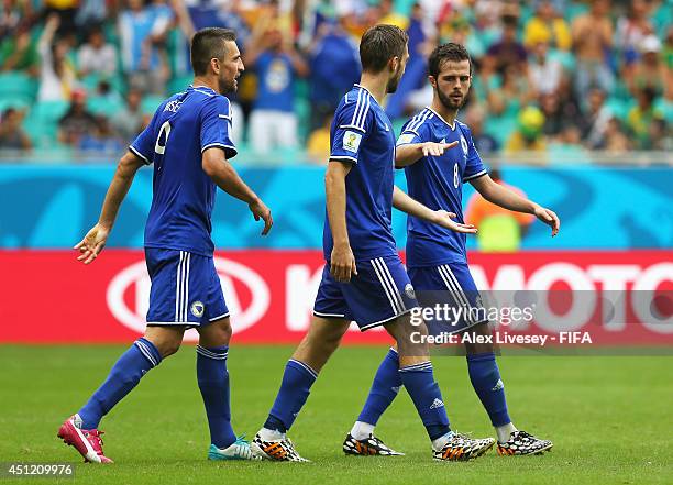 Miralem Pjanic of Bosnia and Herzegovina celebrates scoring his team's second goal with his teammate Tino Sven Susic and Vedad Ibisevic during the...