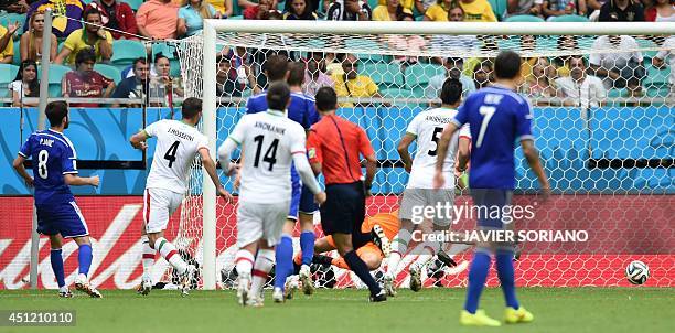 Bosnia-Herzegovina's midfielder Miralem Pjanic kicks the ball past Iran's goalkeeper Alireza Haghighi to score his team's second goal during a Group...