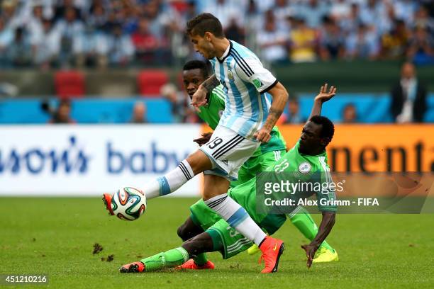 Ricardo Alvarez of Argentina and Juwon Oshaniwa of Nigeria compete for the ball during the 2014 FIFA World Cup Brazil Group F match between Nigeria...