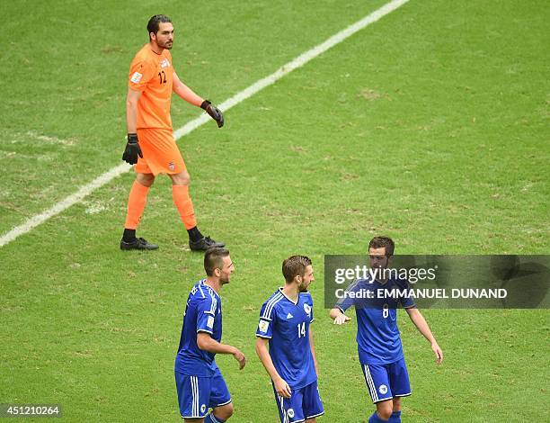 Bosnia-Herzegovina's midfielder Miralem Pjanic celebrates scoring his team's second goal as he walks with Bosnia-Herzegovina's midfielder Tino Sven...