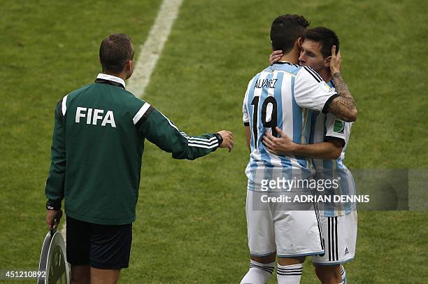 Argentina's forward and captain Lionel Messi embraces Argentina's midfielder Ricky Alvarez after substitution during the Group F football match...