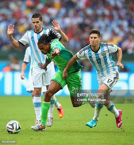 Okechukwu Uchebo of Nigeria controls the ball against Ezequiel Garay and Ricardo Alvarez of Argentina during the 2014 FIFA World Cup Brazil Group F...