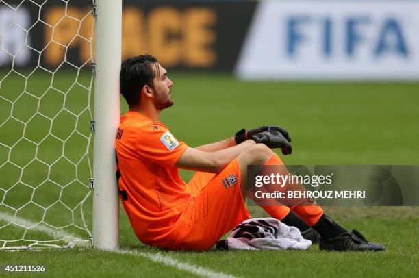 Iran's goalkeeper Alireza Haghighi reacts after his team lost a Group F football match between Bosnia-Hercegovina and Iran at the Fonte Nova Arena in...