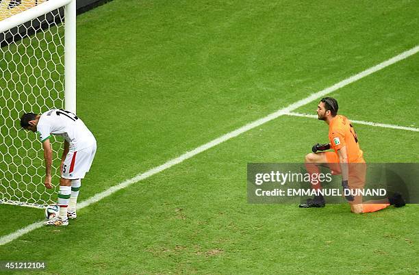 Iran's goalkeeper Alireza Haghighi watches as Iran's defender Pejman Montazeri picks up the ball after Bosnia-Herzegovina's midfielder Avdija...