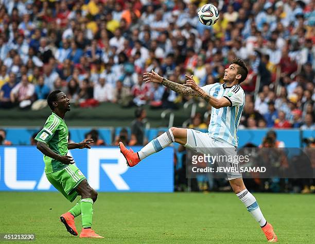 Nigeria's midfielder John Obi Mikel looks on as Argentina's midfielder Ricky Alvarez rises to head the ball during the Group F football match between...
