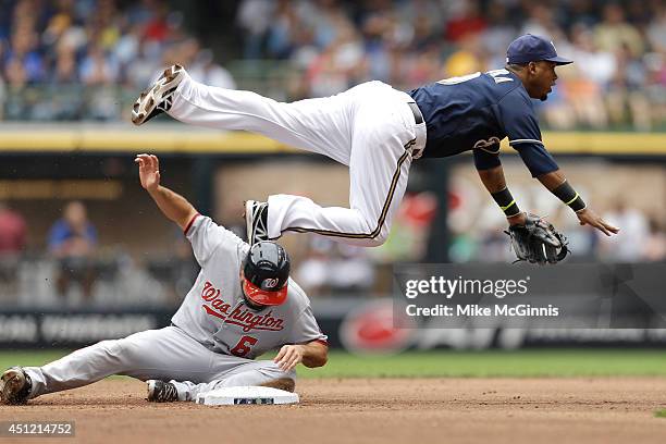 Jean Segura of the Milwaukee Brewers attempts the double play as Anthony Rendon of the Washington Nationals slides into second base during the top of...